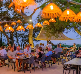 Terrasse du restaurant sous des luminaires en osier