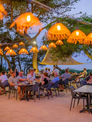 Terrasse du restaurant sous des luminaires en osier